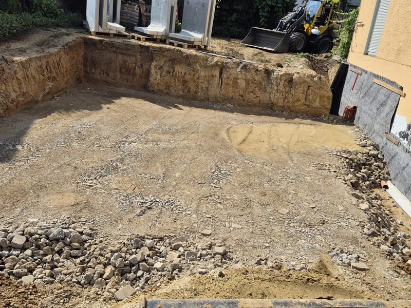 Vorher: Ausgehobene Grube für ein Fundament direkt am Haus