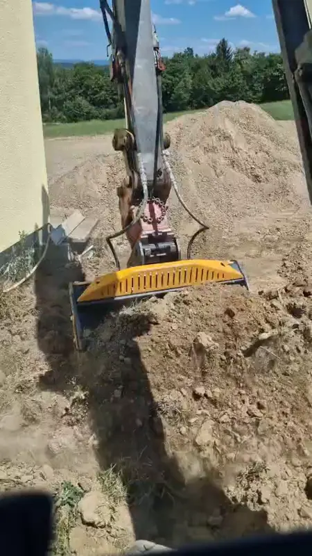 Schaufelseparator am Bagger siebt Erde, feiner Humus fällt heraus